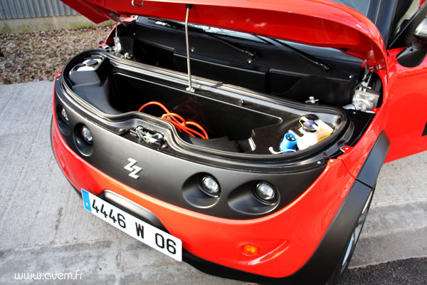 Sous le capot, un petit espace de rangement suppl�mentaire. On peut �galement entrevoir la prise de recharge du v�hicule....